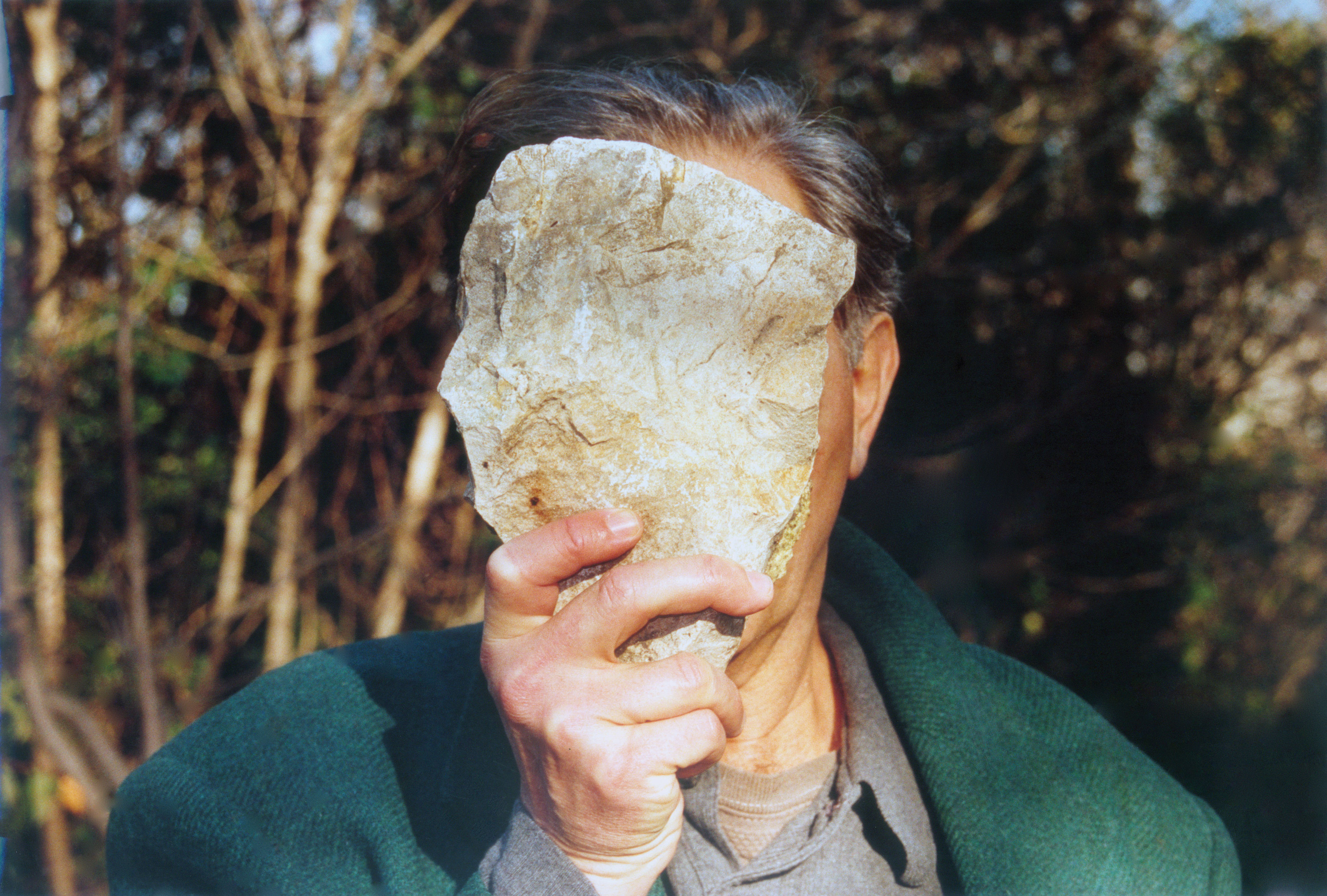 jimmie durham obscuring his face with a stone